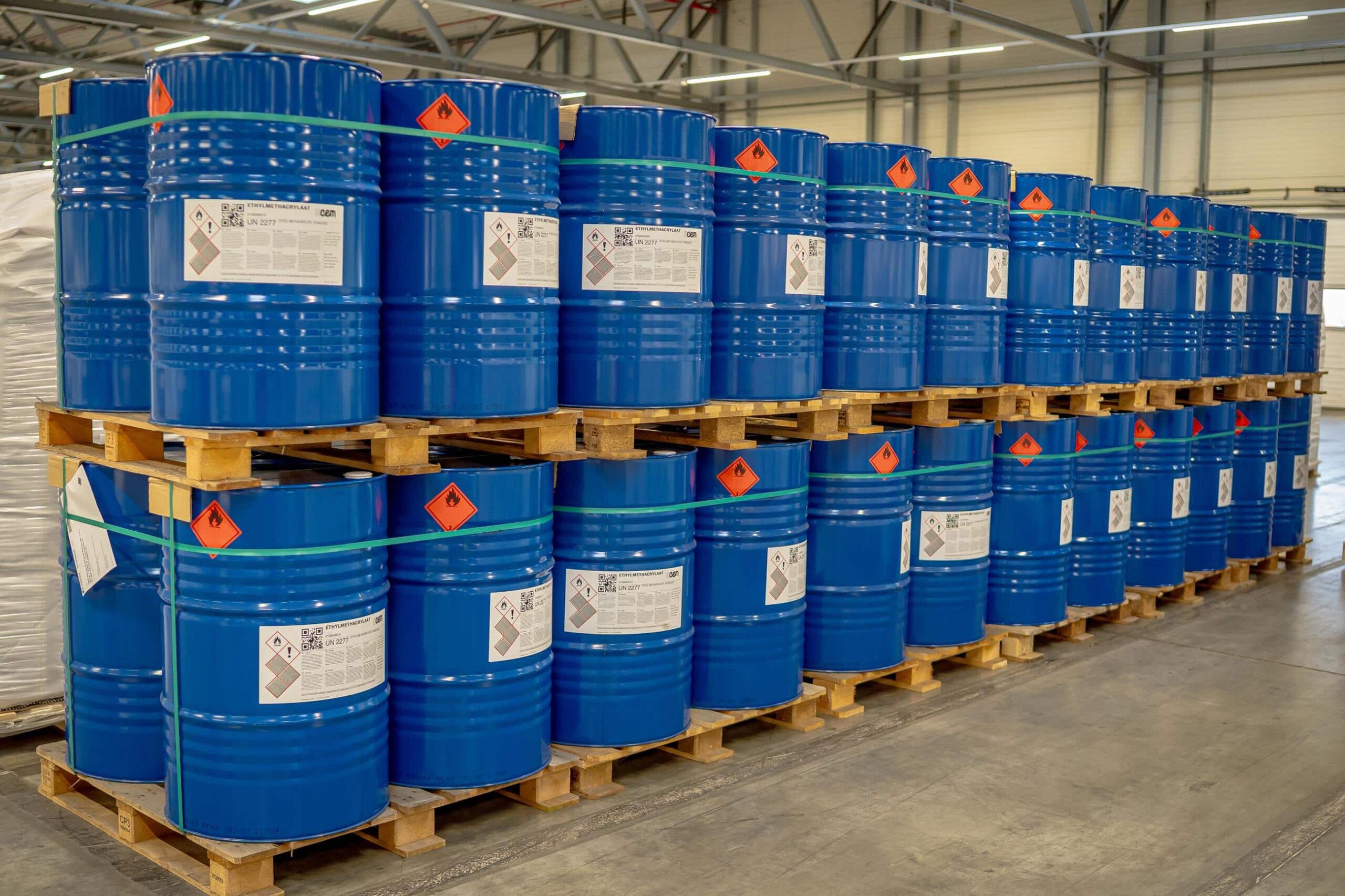 Blauw gelabelde ADR-vaten met gevaarlijke stoffen op pallets in een Alblas opslaghal.