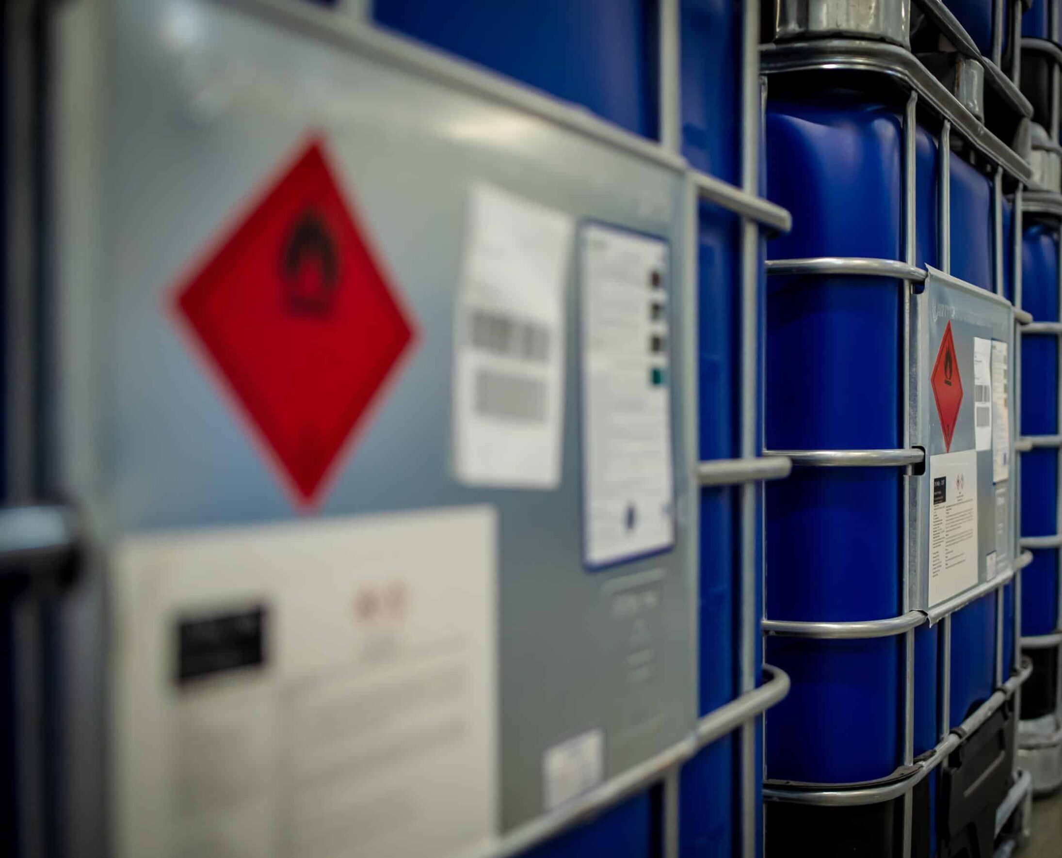 Blauwe IBC-containers met ADR-labels opgeslagen voor veilig transport van gevaarlijke stoffen.