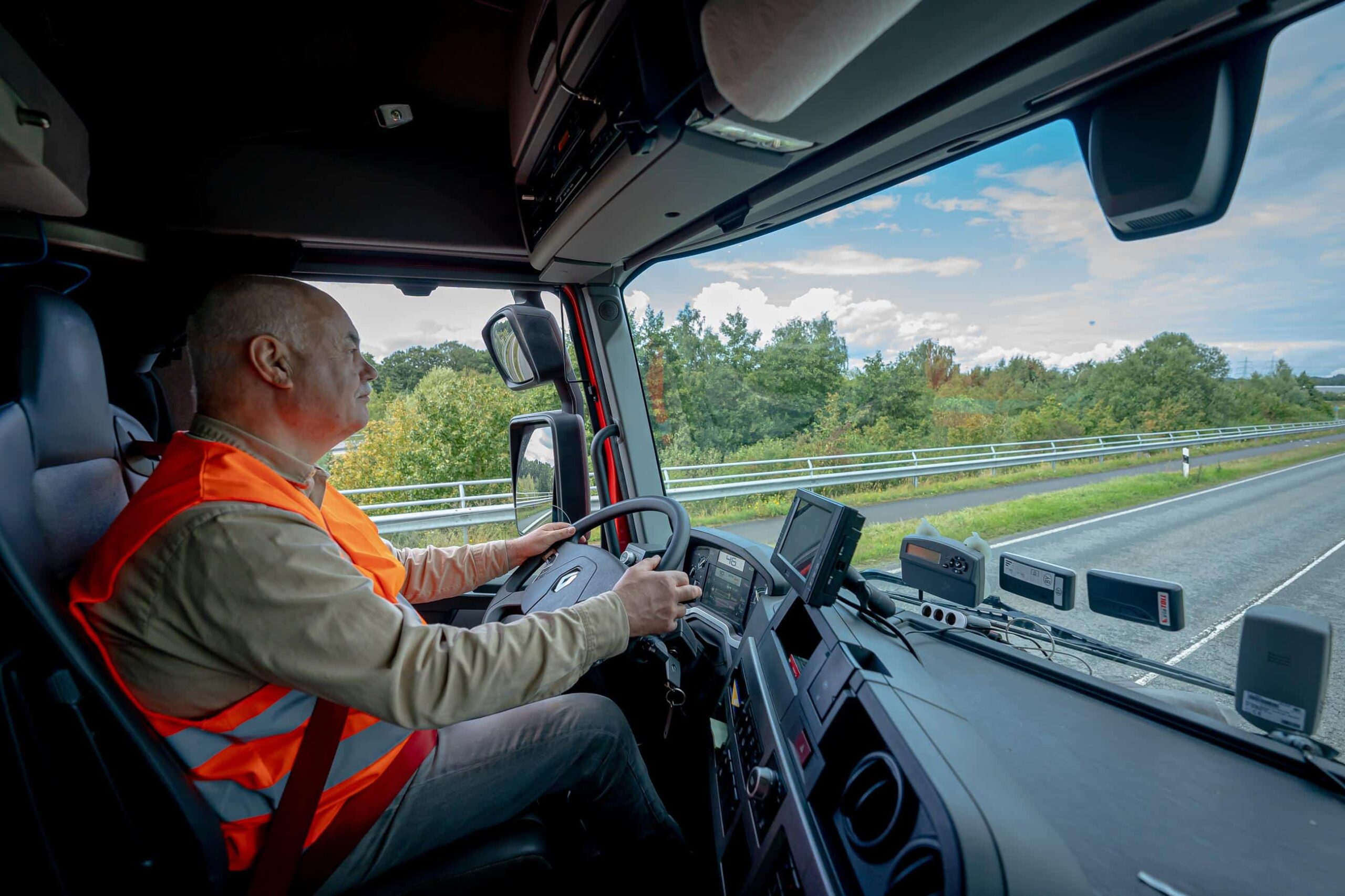 Chauffeur van Alblas rijdt op de snelweg in een vrachtwagen, gezien vanuit de cabine tijdens transport.