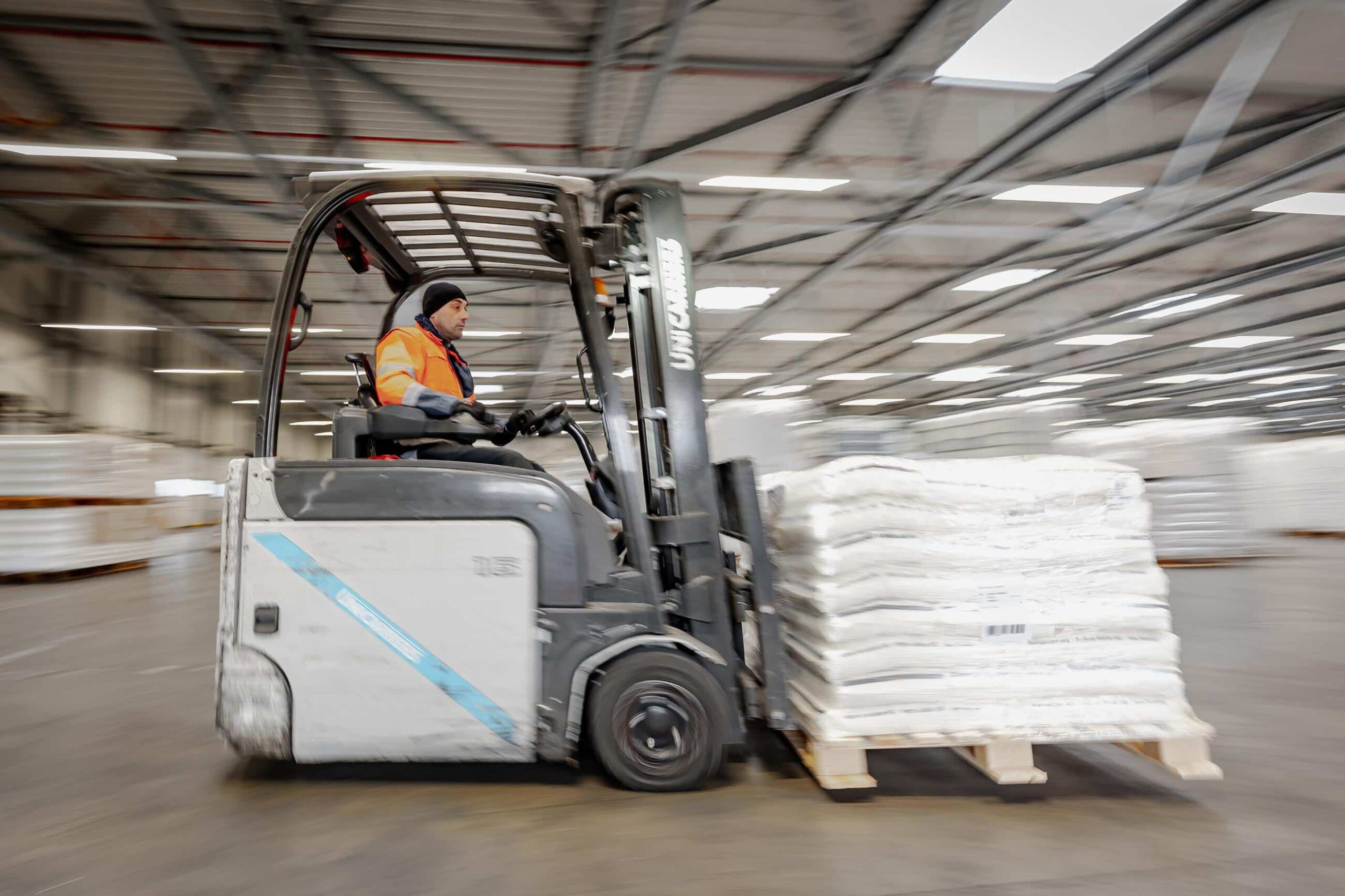 Heftruckchauffeur verplaatst goederen in magazijn van Alblas voor algemeen transport.