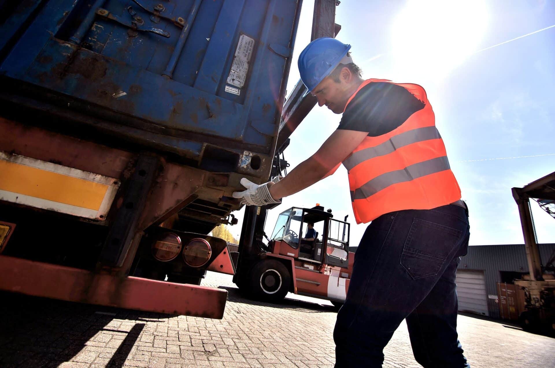 Medewerker van Alblas controleert een container tijdens laadwerkzaamheden op het terrein.