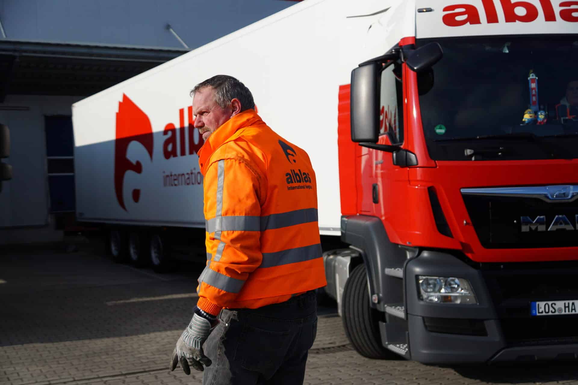 Alblas vrachtwagen bij laaddock met medewerker in veiligheidskleding