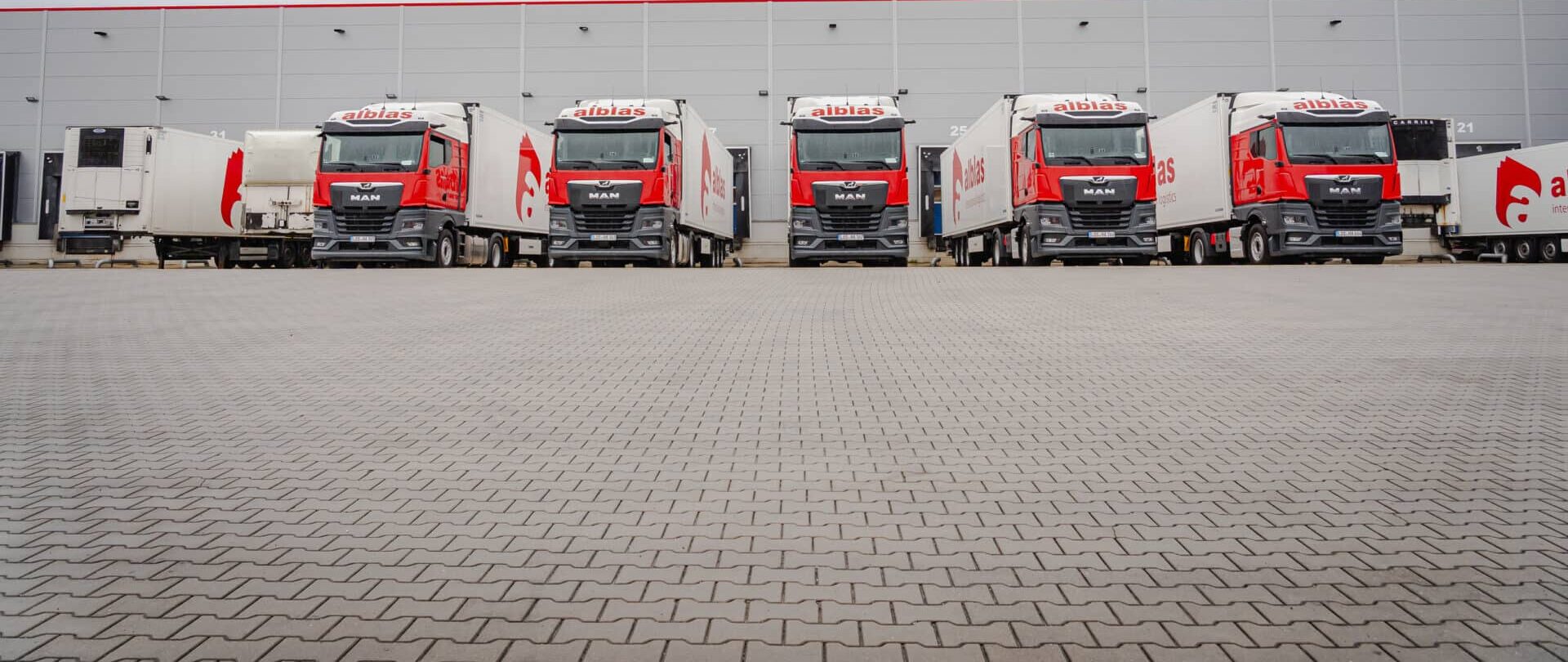 Vrachtwagens van Alblas International Logistics aan het dock van het warehouse